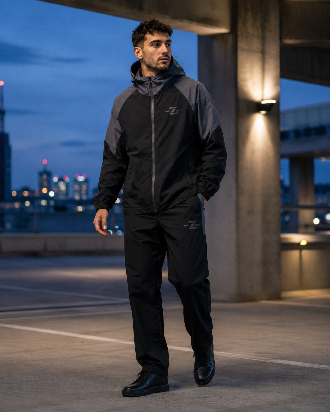 Model wearing ZERO LIMIT Technical Tracksuit Set in Black and Charcoal